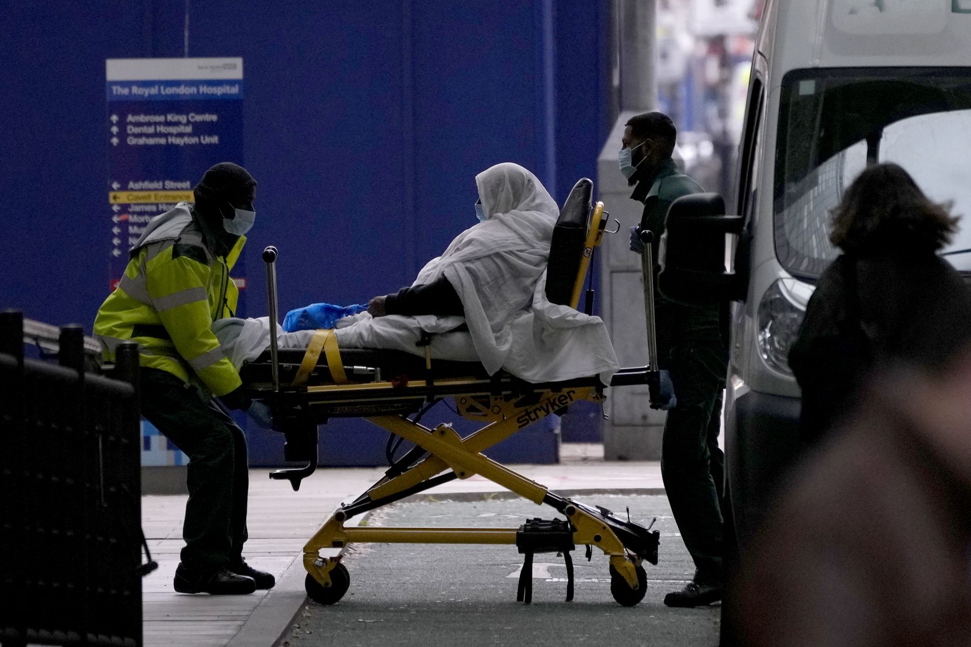 图为1月6日，英国伦敦一间医院，一名病人被擡出救护车。（AP）