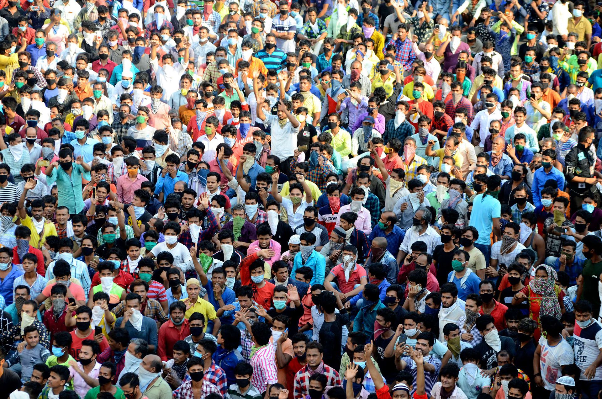 2020年4月14日，星期二，在印度孟买的一个贫民窟，外来务工人员在抗议延长封锁期间高喊口号。（AP）