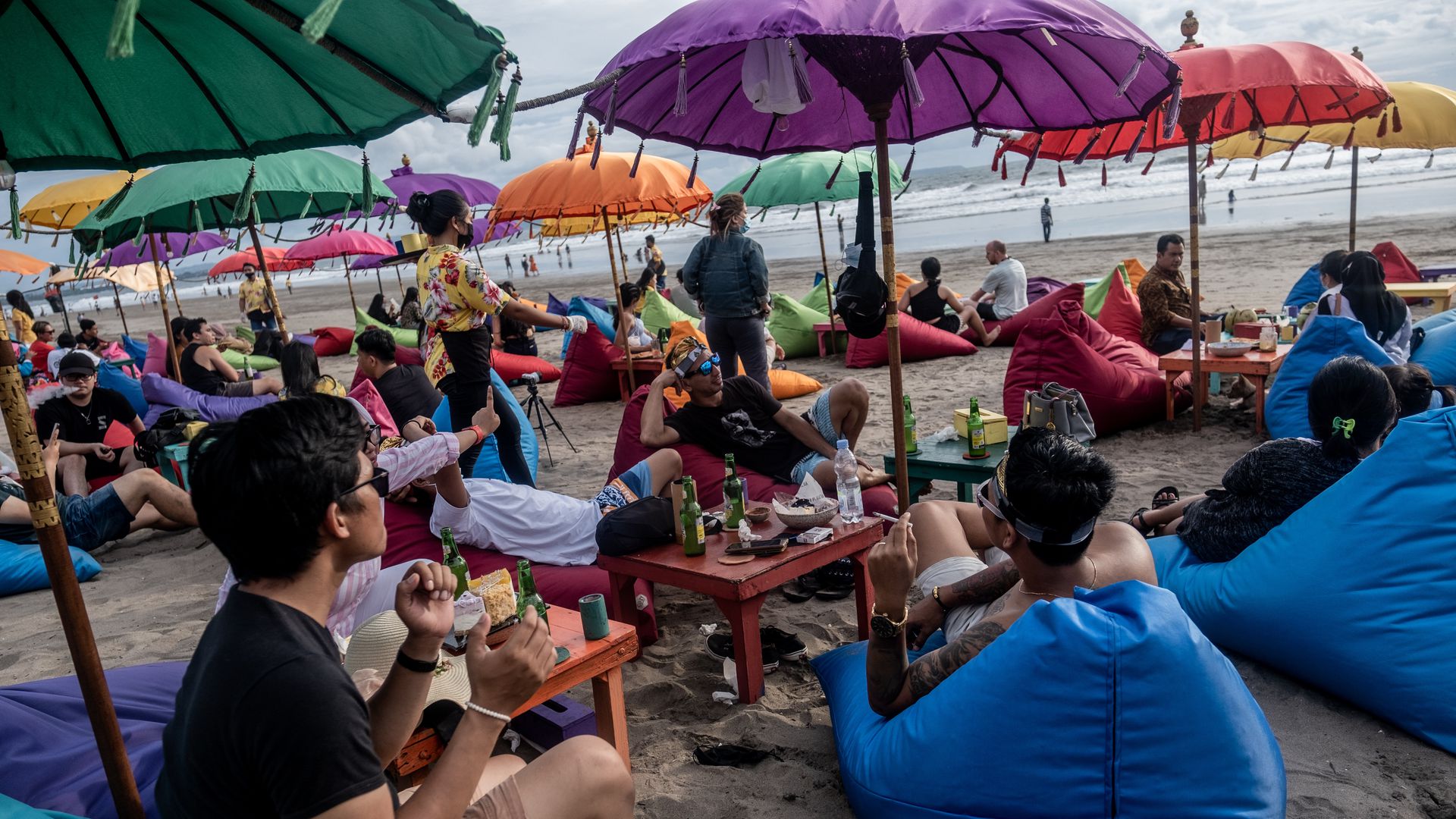 峇里岛：图为1月28日，旅客在印尼峇里岛沙滩上的餐厅用餐。（Getty）