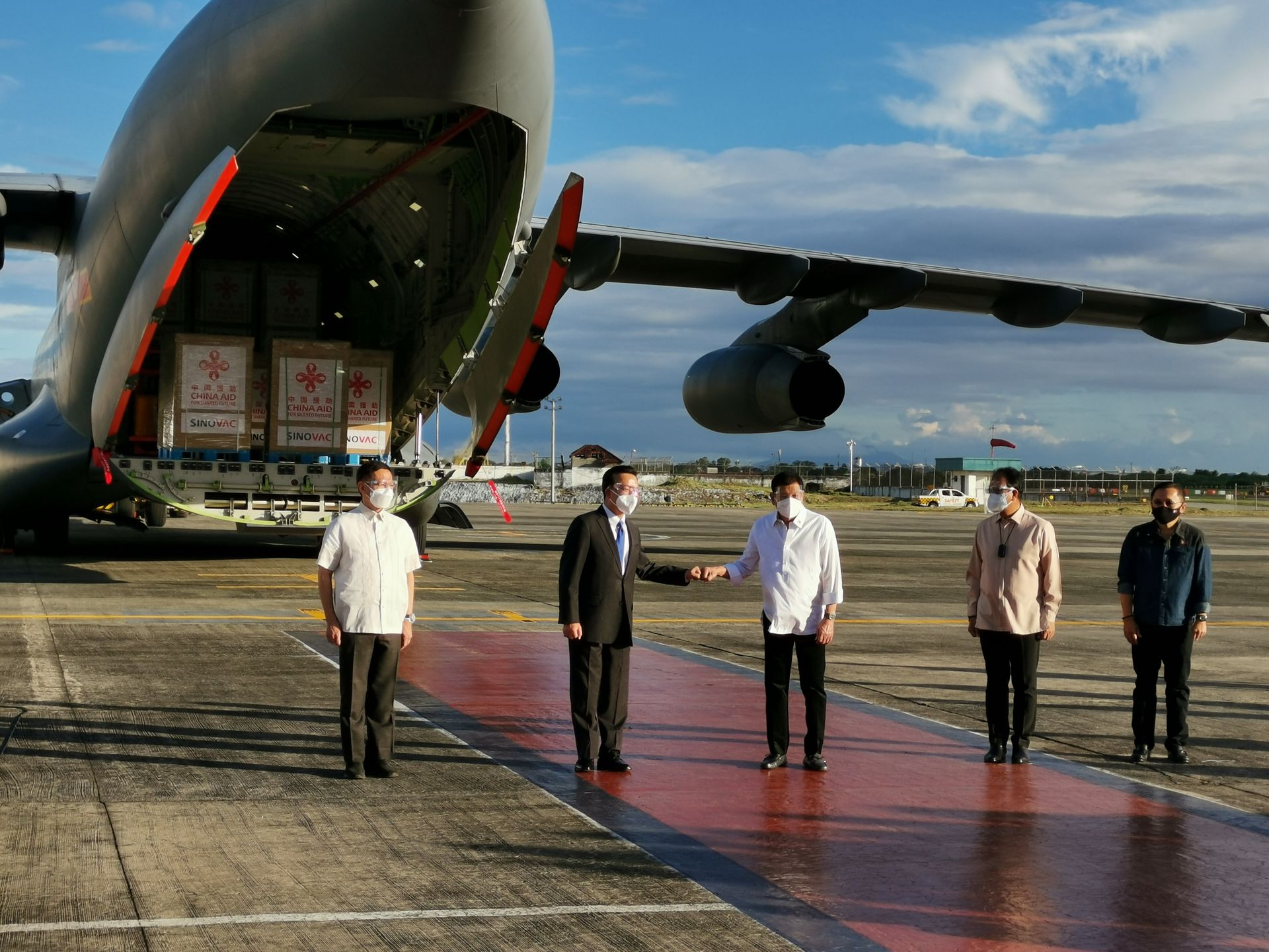 中菲关系：菲律宾总统杜特尔特（中）和中国驻菲律宾大使黄溪连（左二）2月28日赴机场迎接中国援助菲律宾的60万剂新型冠状病毒肺炎疫苗。（中国驻菲律宾大使馆）
