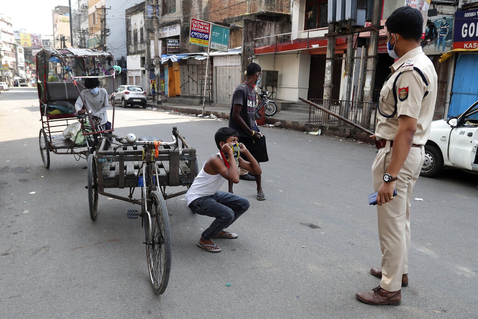 印度新冠肺炎疫情：图为5月14日印度高哈蒂有警员在惩罚违反防疫规定的男子。（AP）