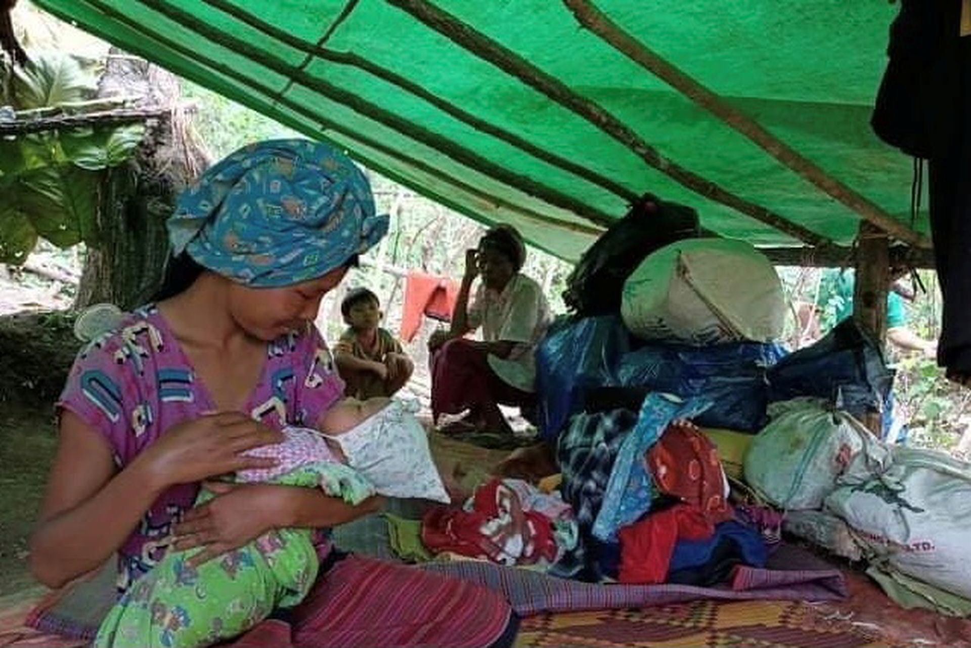 图为一名因国内东部战事流离失所的女子，5月26日在缅甸克耶邦的营地内照顾幼婴。（Reuters）