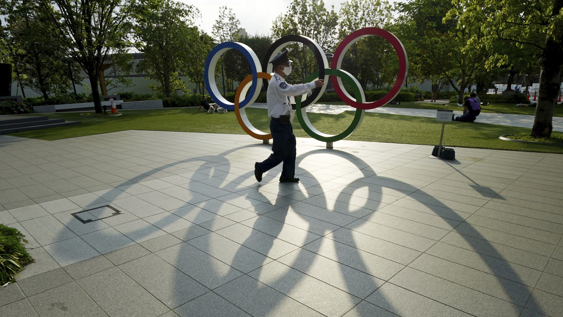 日本新冠肺炎疫情：图为5月9日，日本东京一名保安员经过一个奥运五环摆设前。（AP）