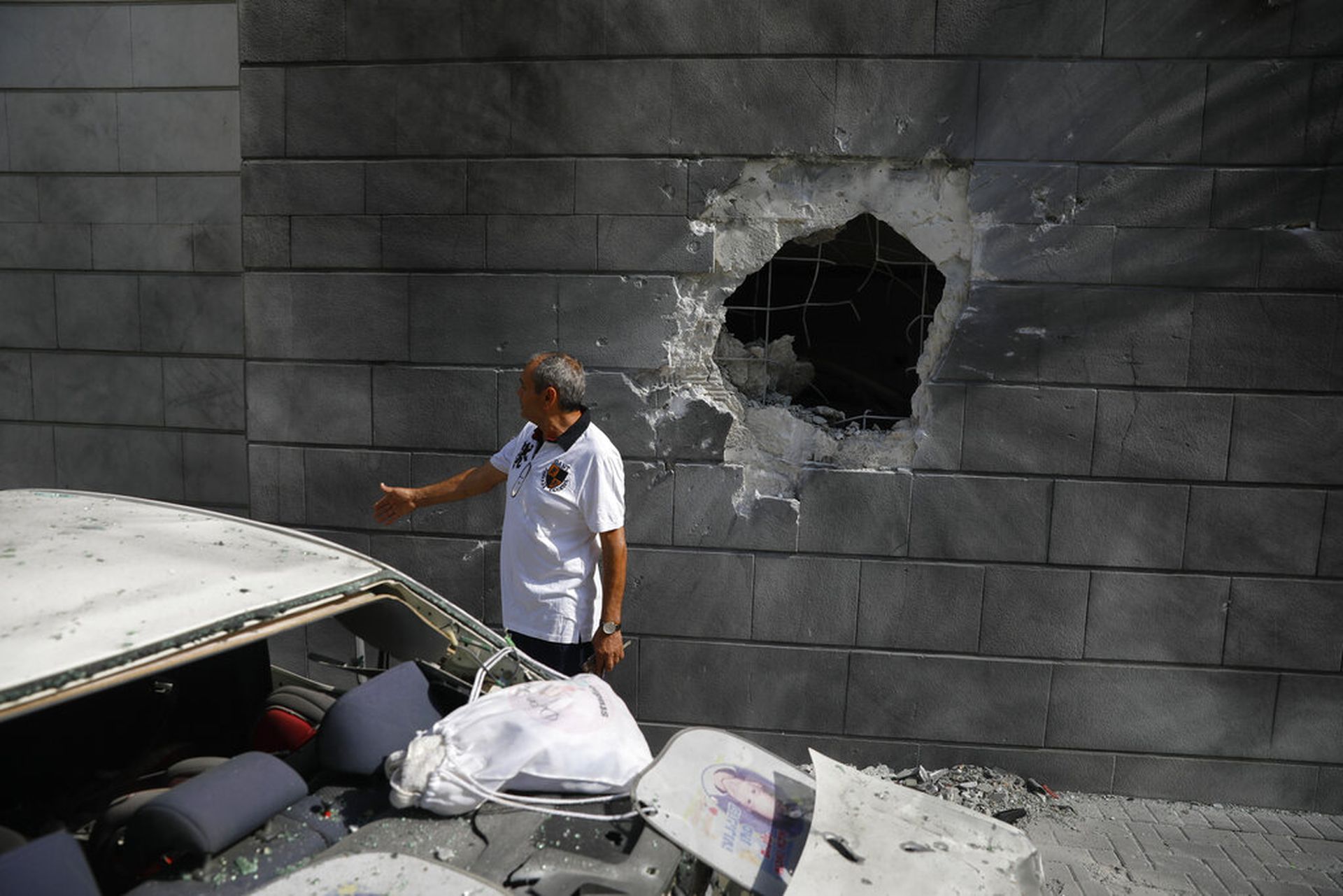 5月14日，加沙地带阿什克隆一名男子，正检视一幅在受损的墙壁。（AP）