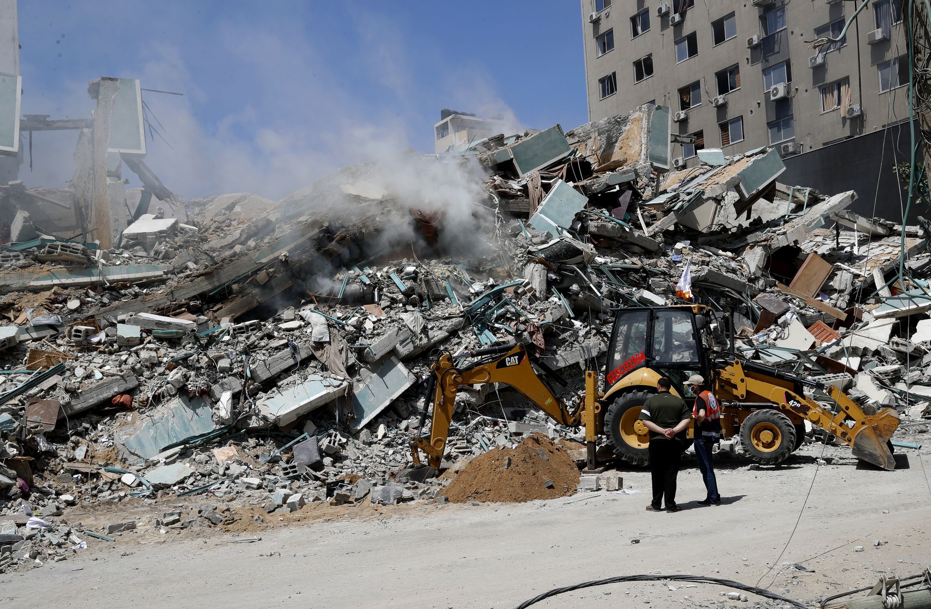 以色列军队炸毁加沙一栋大楼。5月16日，工人清理瓦砾堆。（AP）