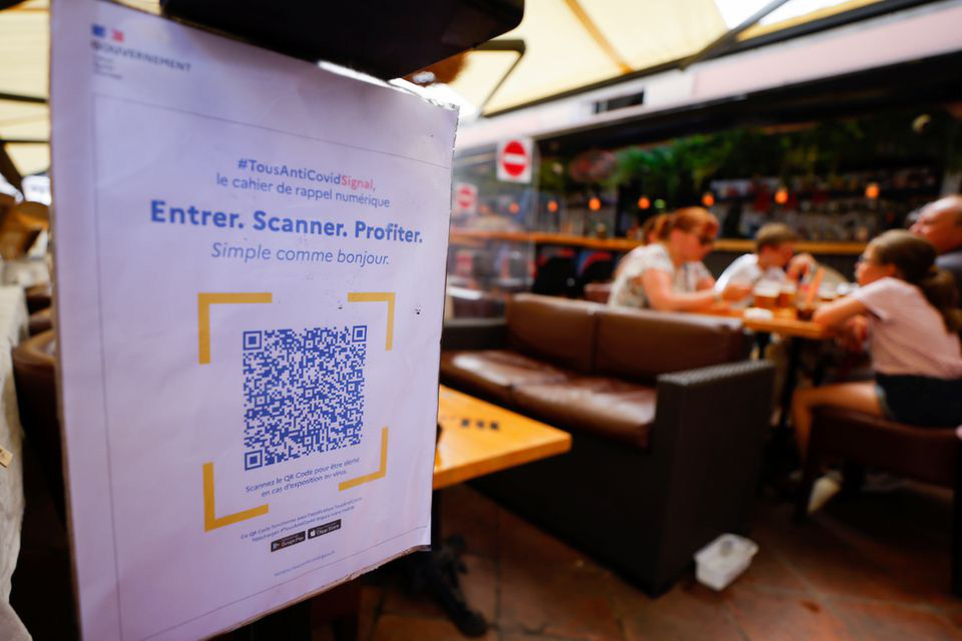 2021年8月9日，在法国尼斯的一家餐馆门口放置的告示牌，提醒人们扫描健康通行码。（Reuters）