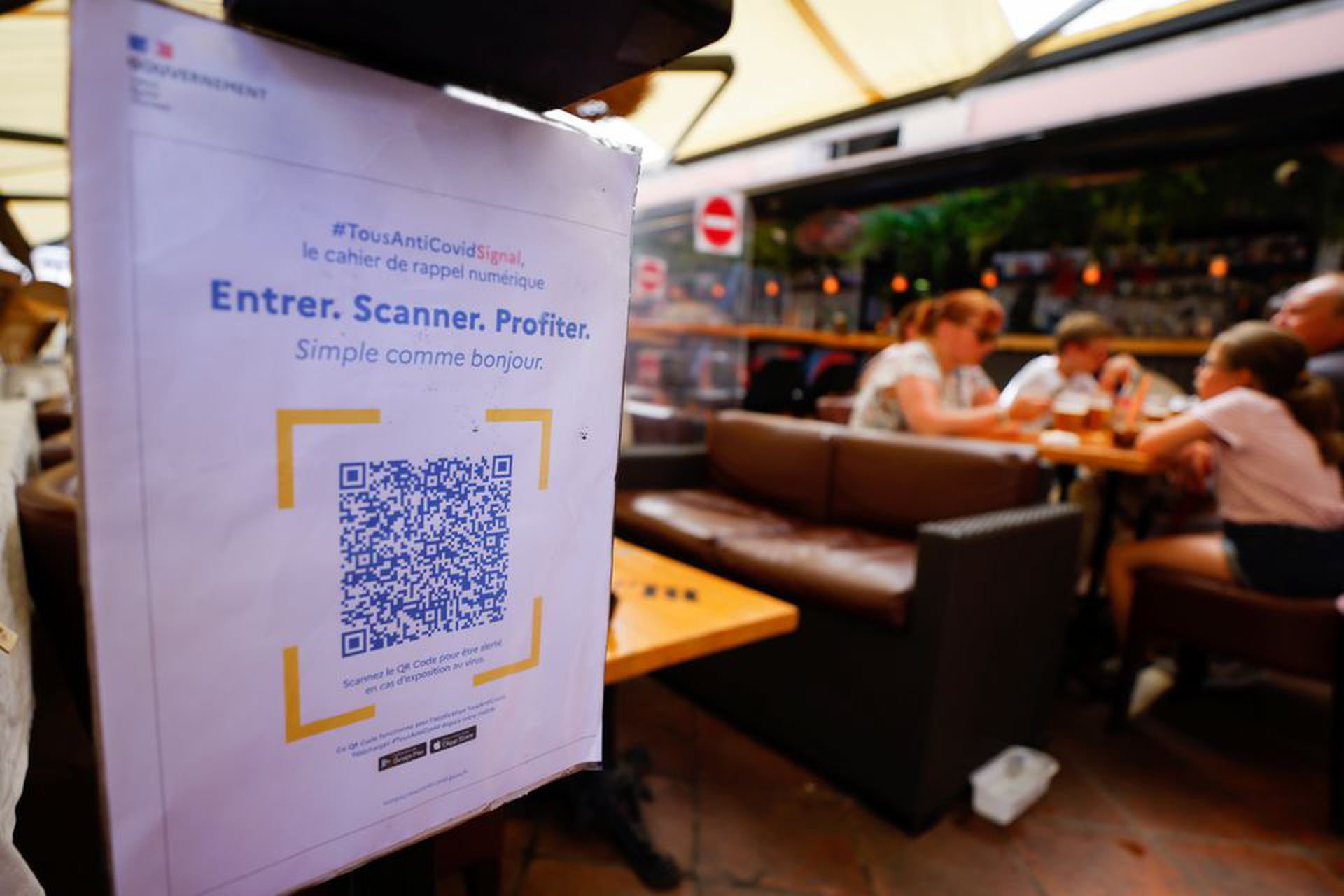 Le 9 août 2021, un panneau a été placé à la porte d'un restaurant de Nice, en France, rappelant aux gens de scanner le code du pass sanitaire. (Reuters) 2021年8月9日,在法国尼斯的一家餐馆门口放置的告示牌,提醒人们扫描健康通行码。(Reuters)