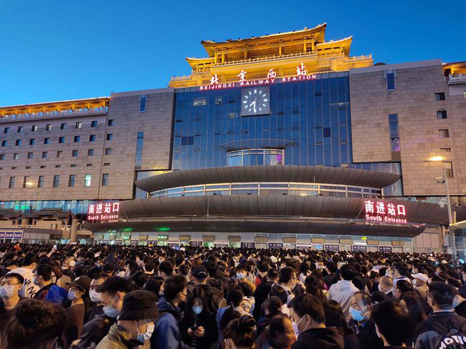 因部分列车停运，5月1日很多旅客无法进站，聚集在北京西站南广场。（新华社）