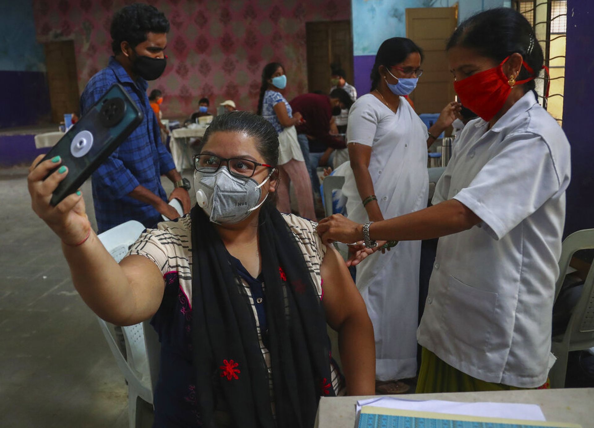 印度新冠肺炎疫情：图为6月13日，一名女子于海得拉巴接种印度国产疫苗Covishield时以手机自拍。（AP）