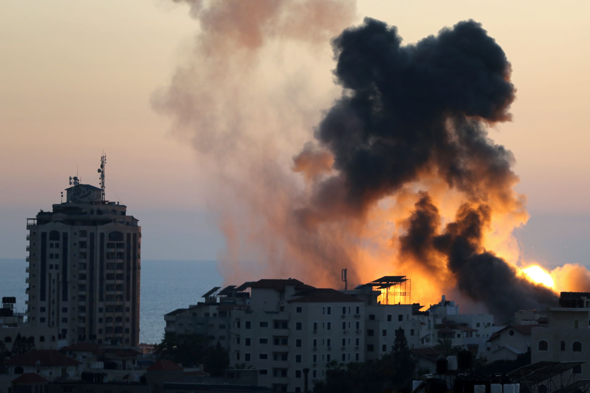 5月14日，以军再空袭加沙地区，有建筑物被击中后冒出大量火光和浓烟。（Reuters）