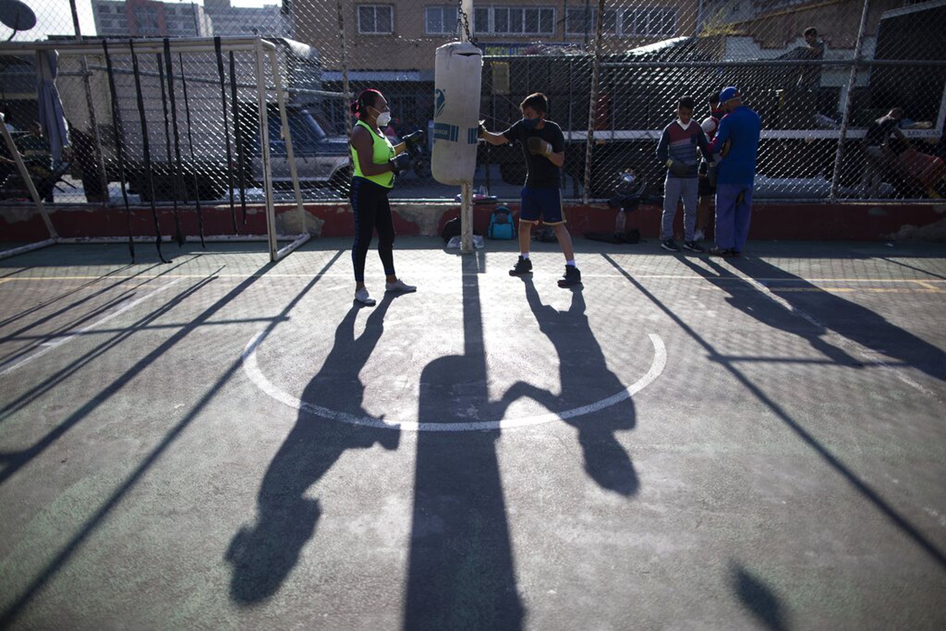委内瑞拉新冠肺炎疫情：图为1月28日一名拳击教练在加拉加斯一住宅区提供免费的训练，年轻人强身健体，减少感染风险。（AP）
