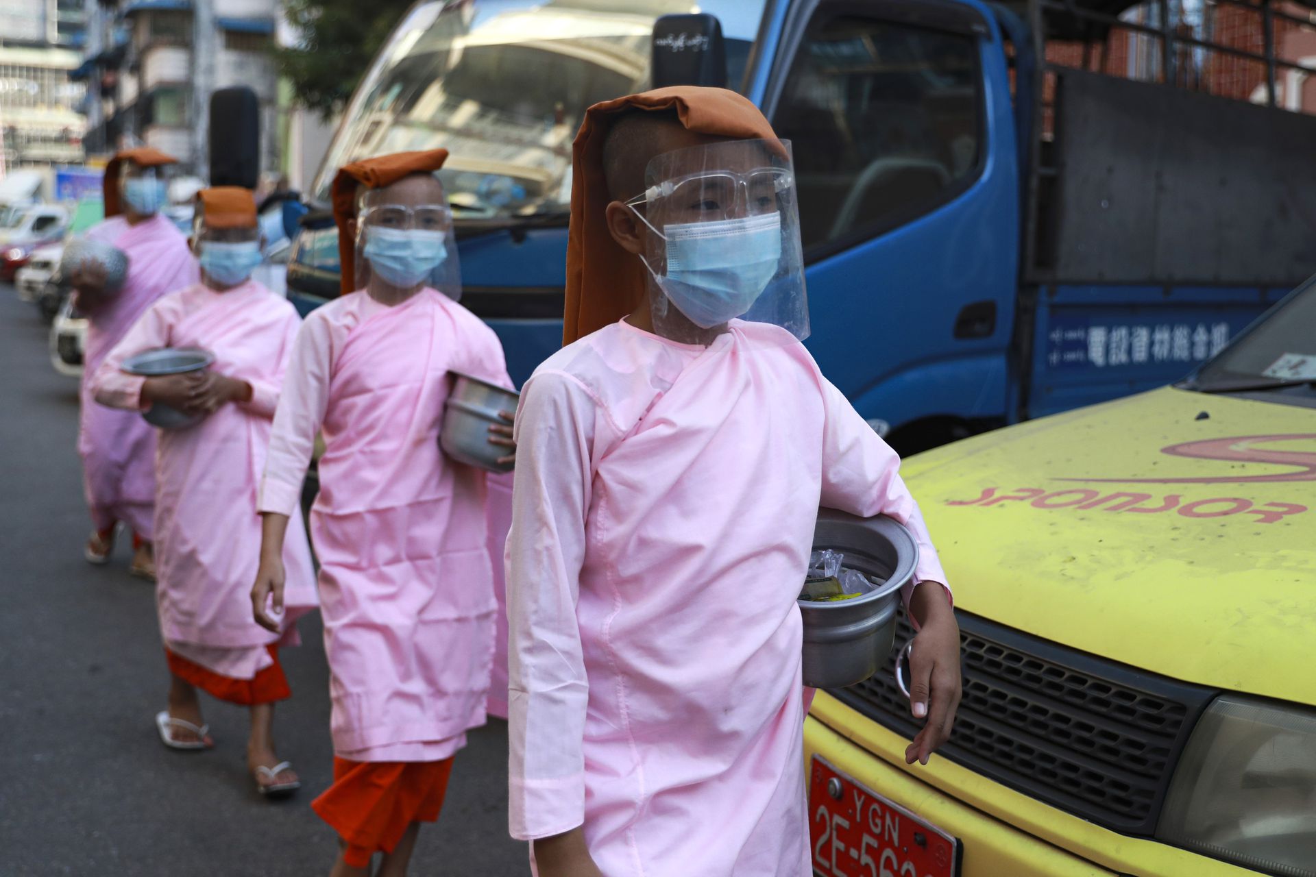 缅甸新冠肺炎疫情：图为2月3日佛教尼姑在仰光去找善众化缘。（AP）