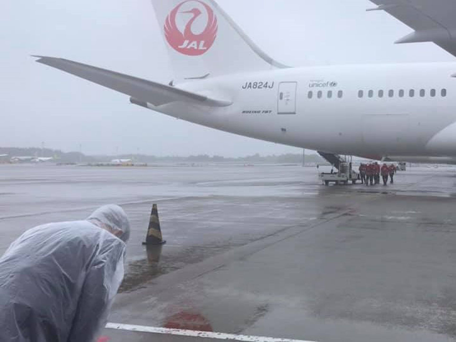 日本赠送124万剂阿斯利康疫苗给台湾，6月4日搭乘日航班机载送，台驻日代表谢长廷站在雨中鞠躬送机。（Facebook@谢长廷）