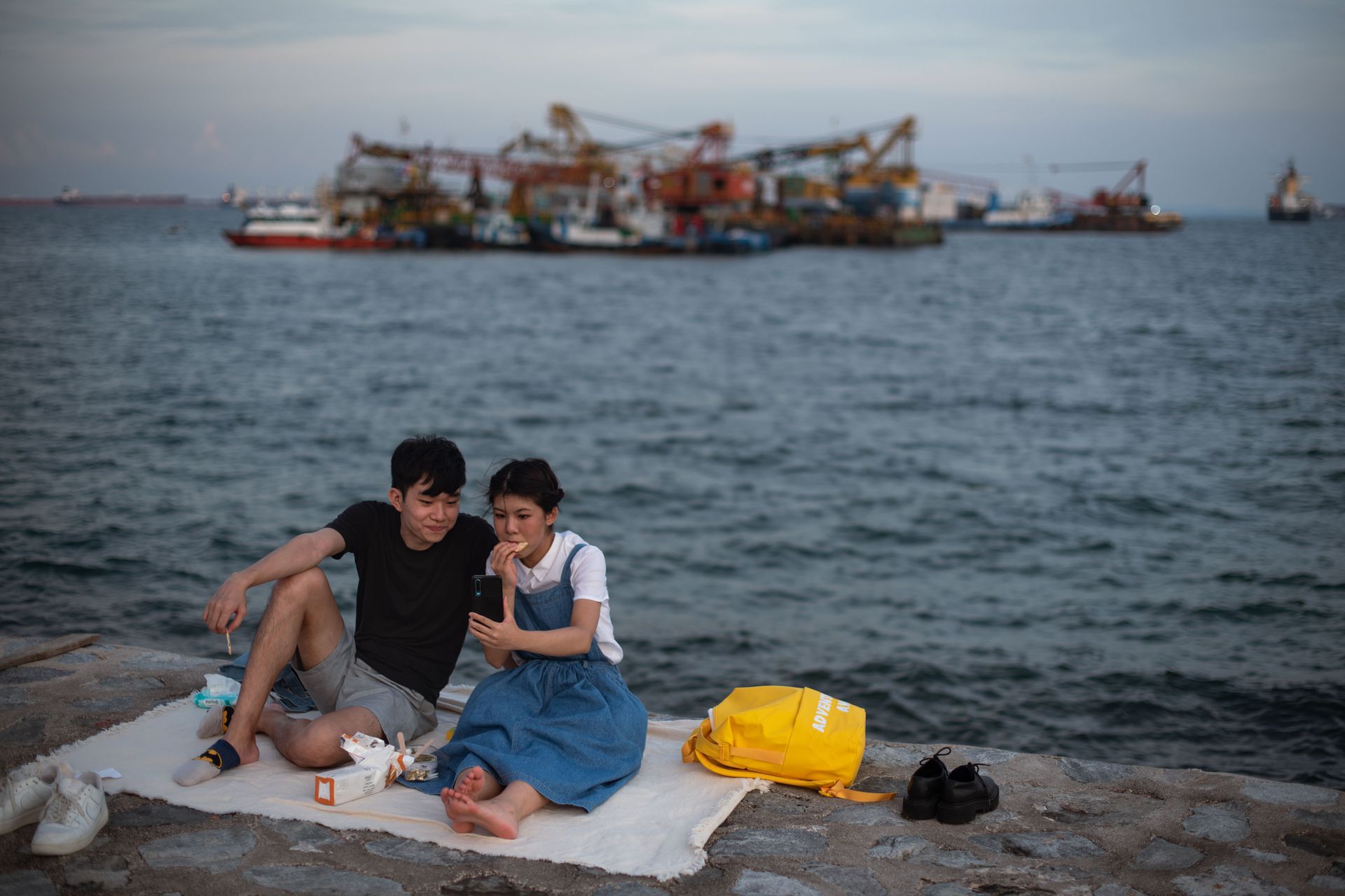 新加坡新冠肺炎疫情：图为6月6日新加坡一对情侣在马里纳湾的防波堤野餐。（Getty）