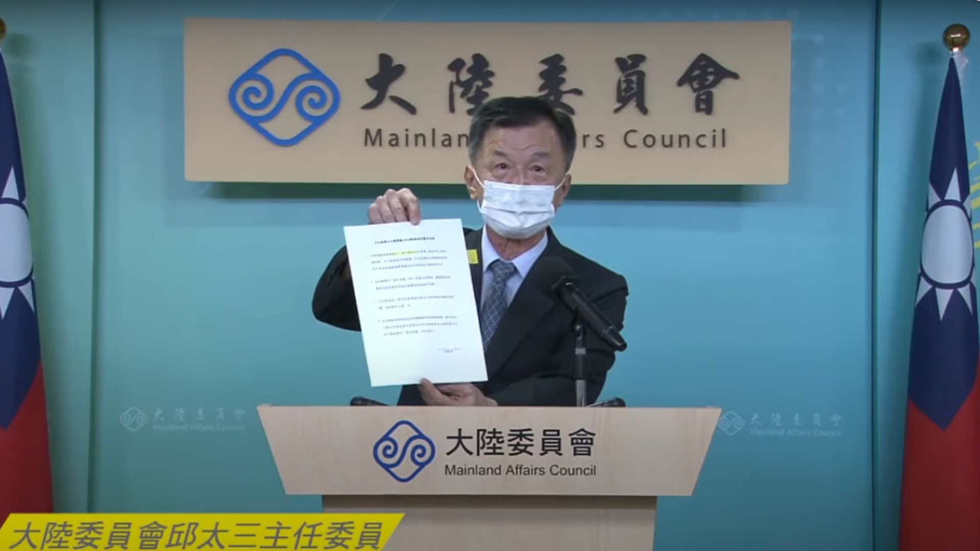 台陆委会主委邱太三于记者会中出示港府要求台湾官员签署的“一中承诺书”。（Youtube@陆委会）