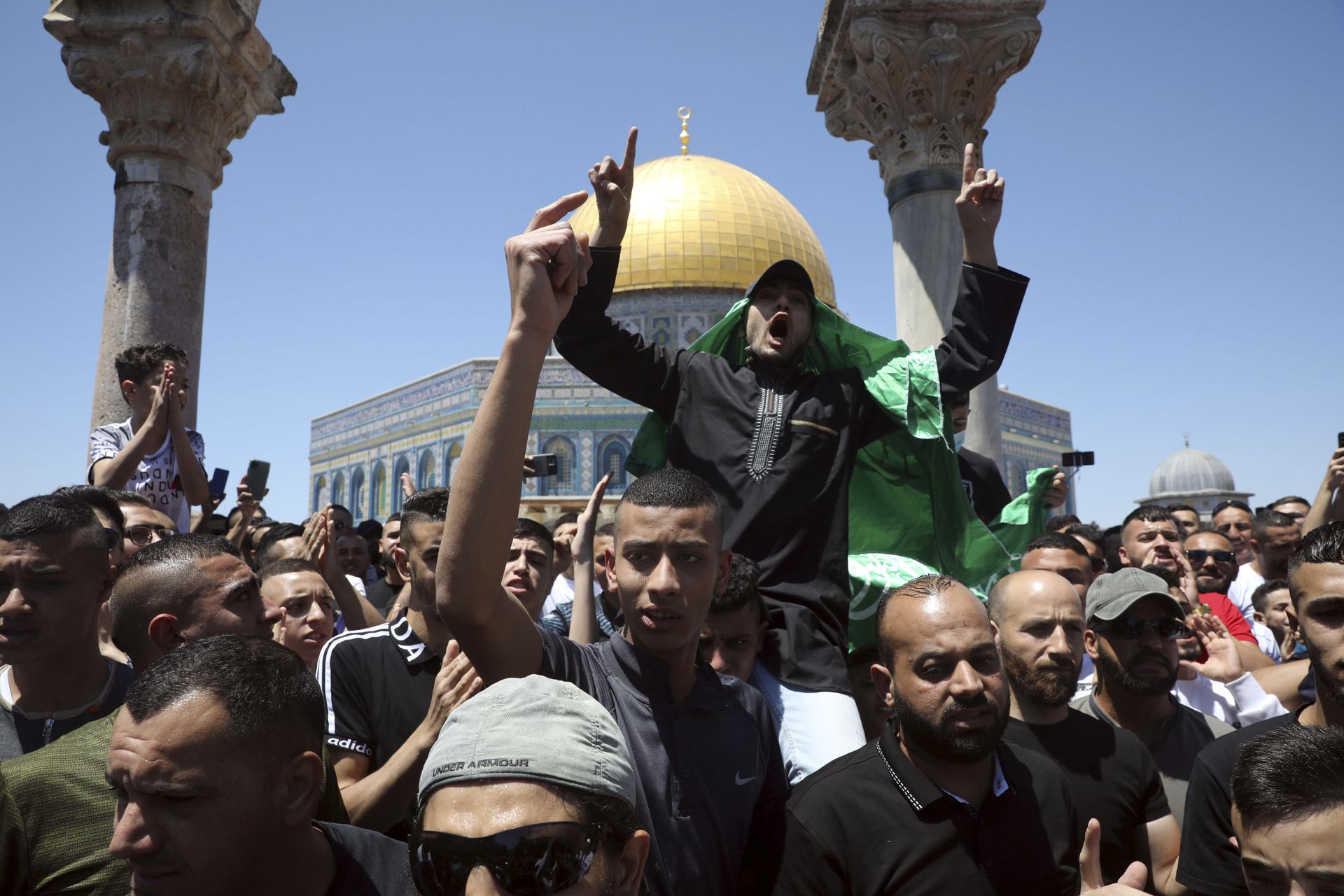 5月14日，穆斯林在阿克萨清真寺祈祷后，在门外进行示威。有人身披哈马斯的旗帜。（AP）