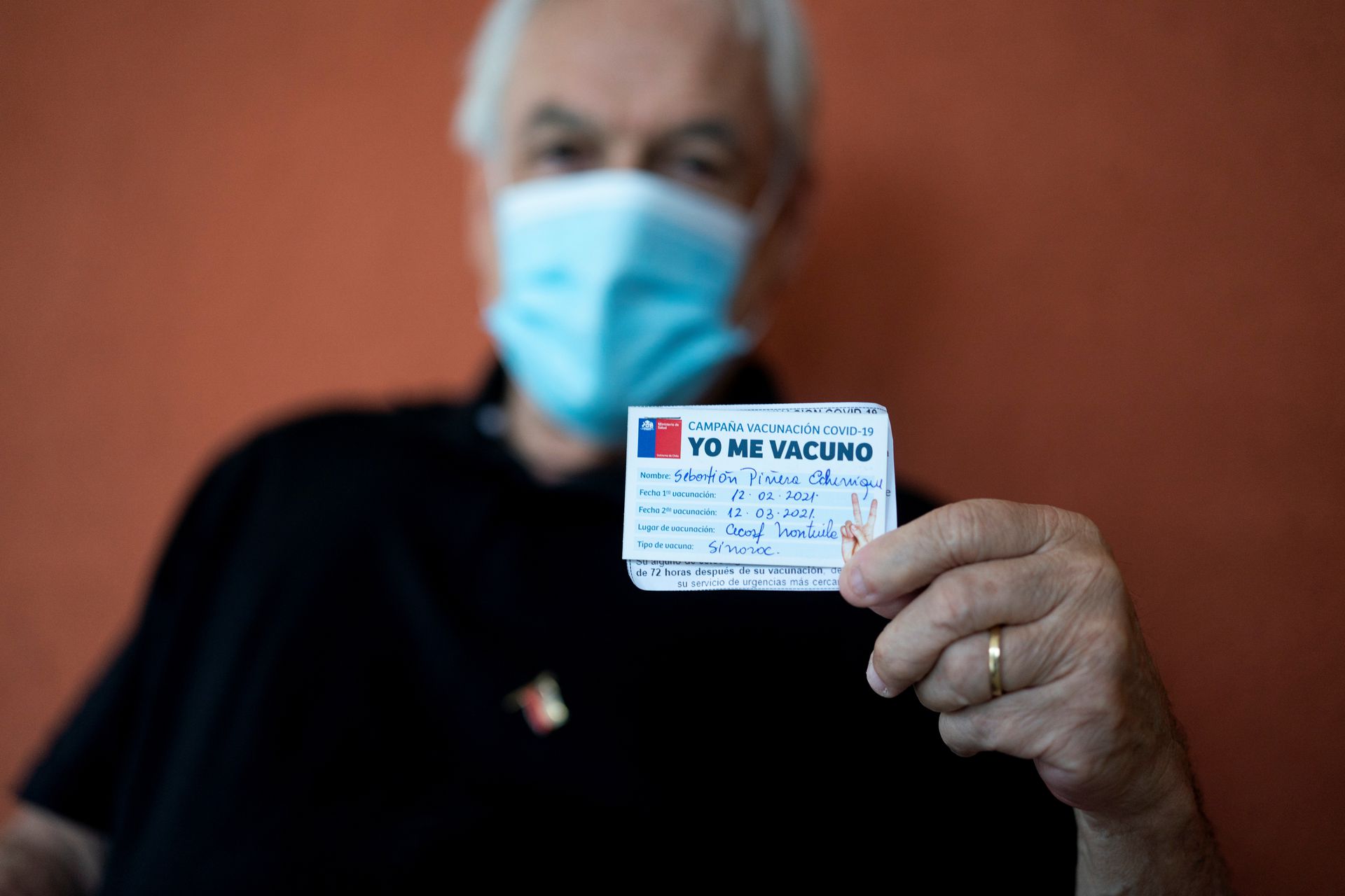 图为2021年2月12日，智利总统皮涅拉于智利河大区福德罗诺市的一间社区家庭保健中心接种中国科兴公司研发的新冠疫苗，其后展示自己的接种卡片。中国疫苗也让智利成为拉美地区仅次于美国的疫苗接种国家。（路透社）