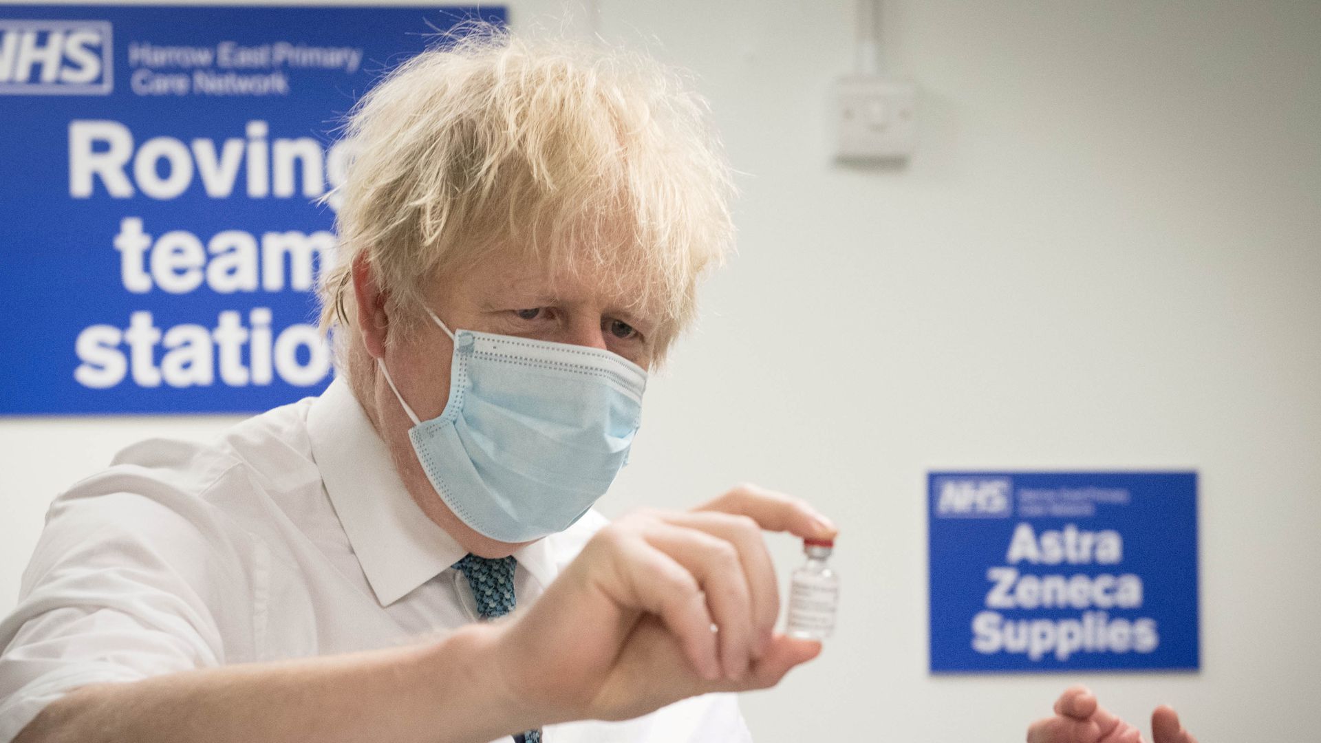 新冠疫苗：图为1月25日，英国首相约翰逊在伦敦一个疫苗接种中心内，手持牛津大学与药厂阿斯利康合力研发的新冠疫苗。（Reuters）