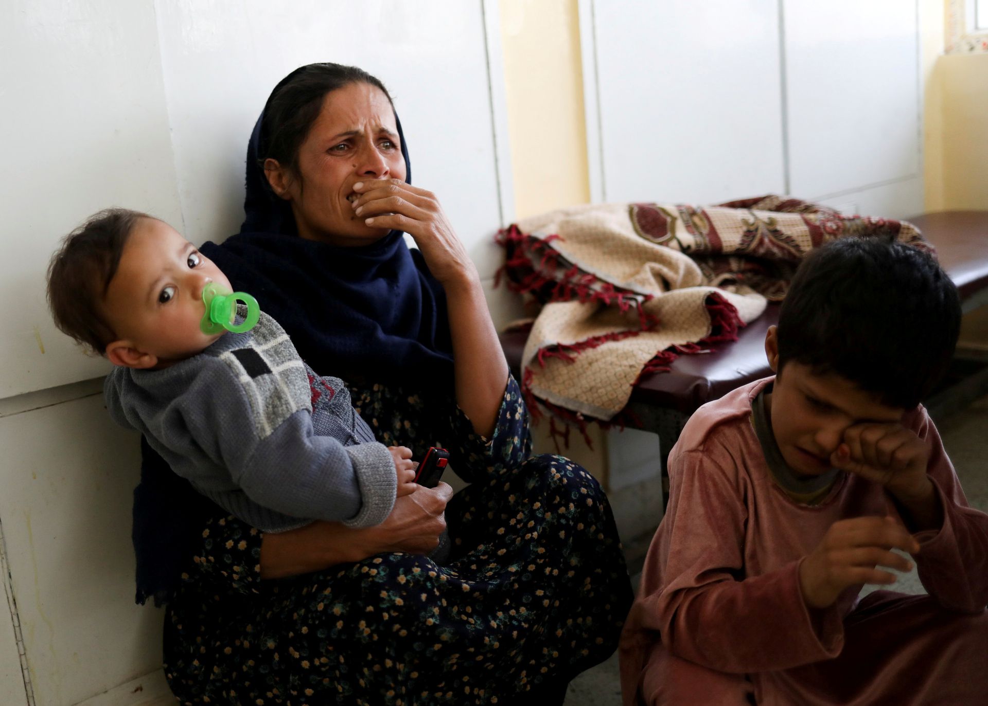军事医院爆炸发生后，一名在儿童医院的女性及孩子受到惊吓。（Reuters）