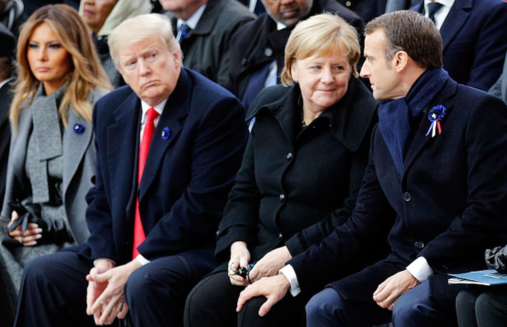 2018年11月11日，在巴黎举行的一战结束百年的纪念活动中，德国总理默克尔与法国总统马克龙亲切交谈。远道而来的美国总统特朗普则显出某种无法插话的局促。（Getty Images）