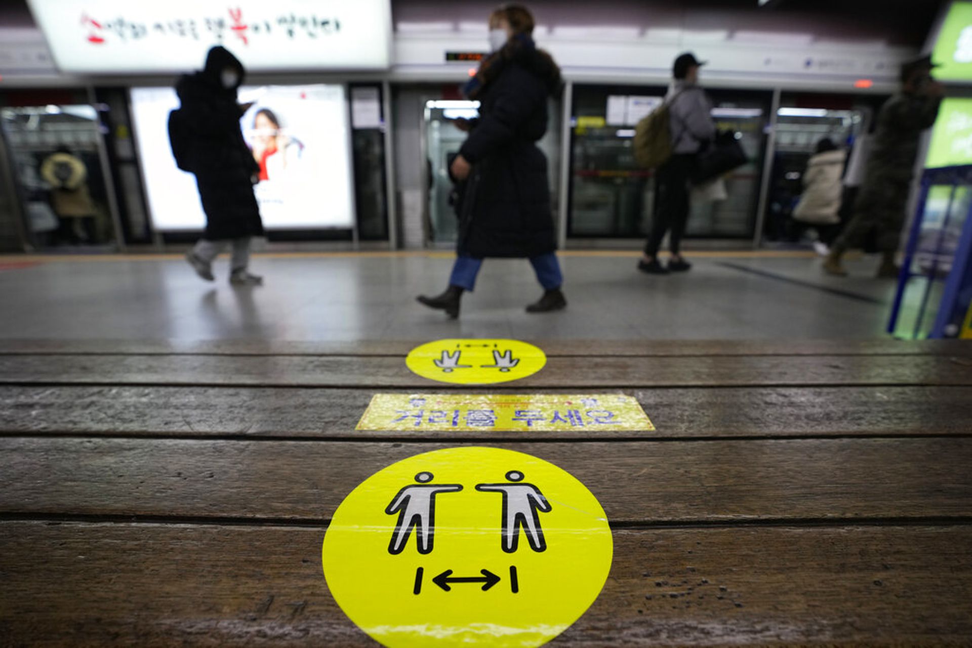 韩国新冠肺炎疫情：图为2021年12月27日，首尔地铁站内一张长椅上贴有呼吁人们保持距离的标贴。（AP）
