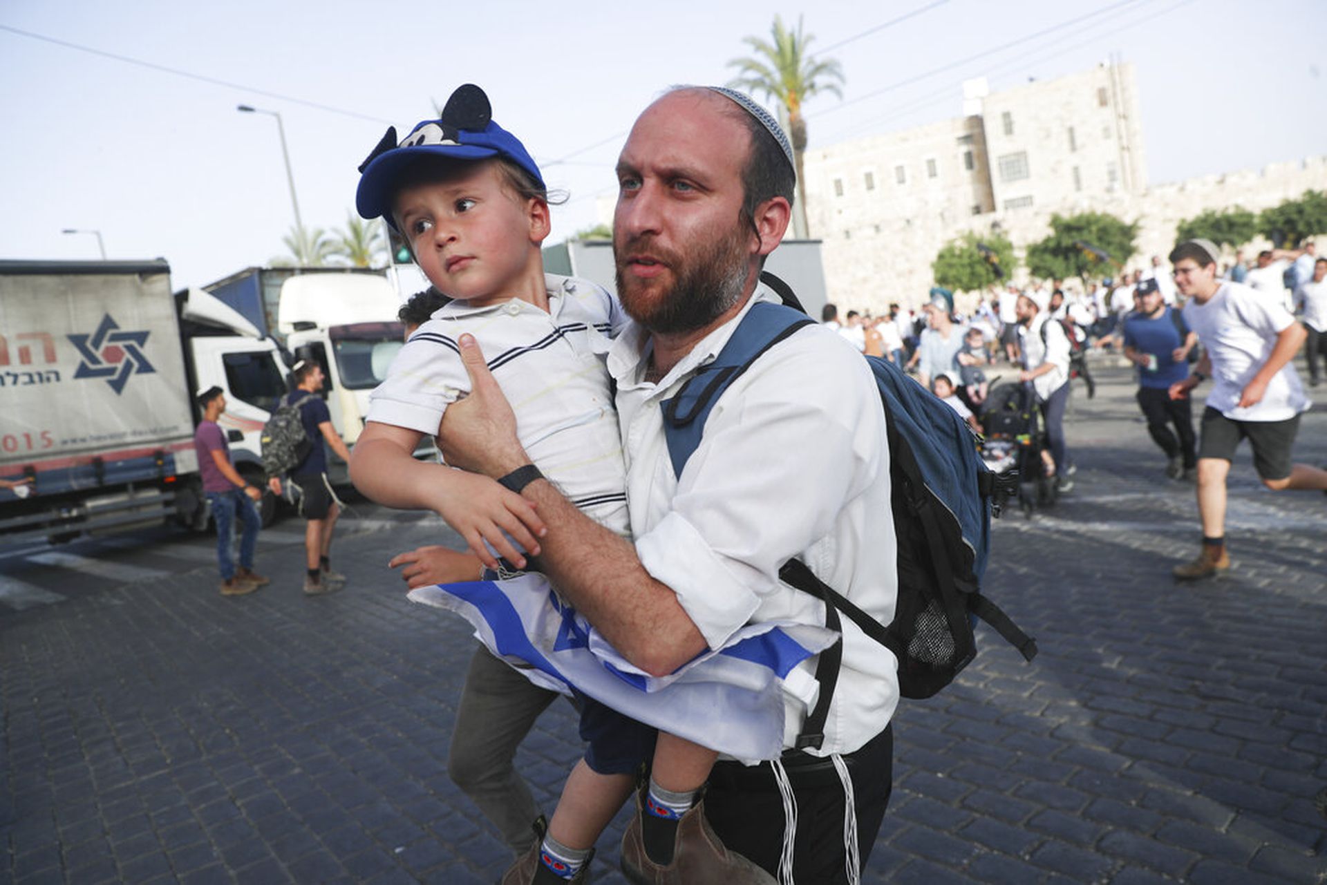 以巴冲突：图为5月10日，正在参加“耶路撒冷日”游行的以色列人听到防空警报，随之奔跑寻找可供掩护的地方。（AP）