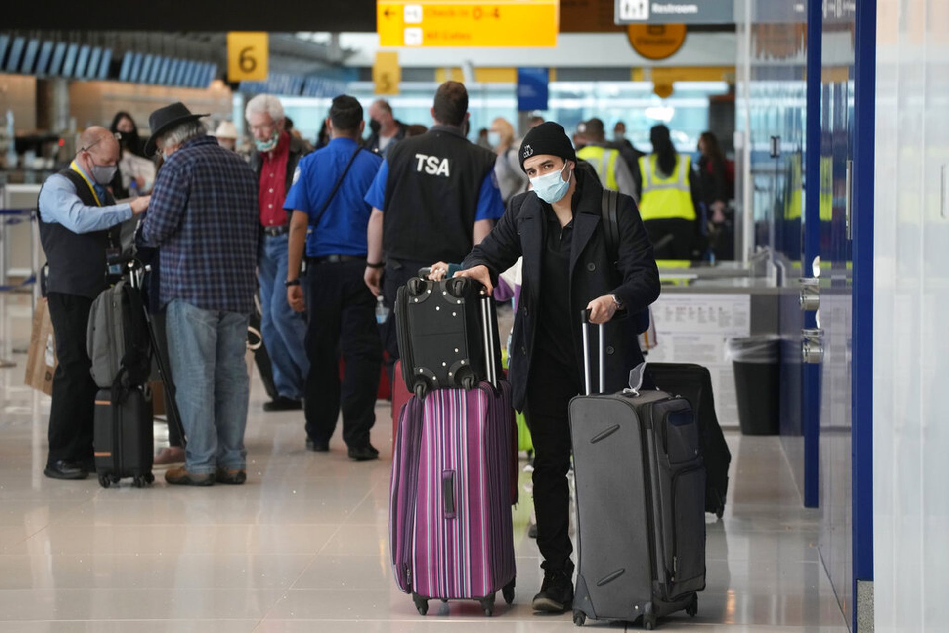 美国新冠肺炎疫情：图为2021年12月26日，一名乘客推着行李路过丹佛国际机场内美国联合航空公司的柜位。（AP）