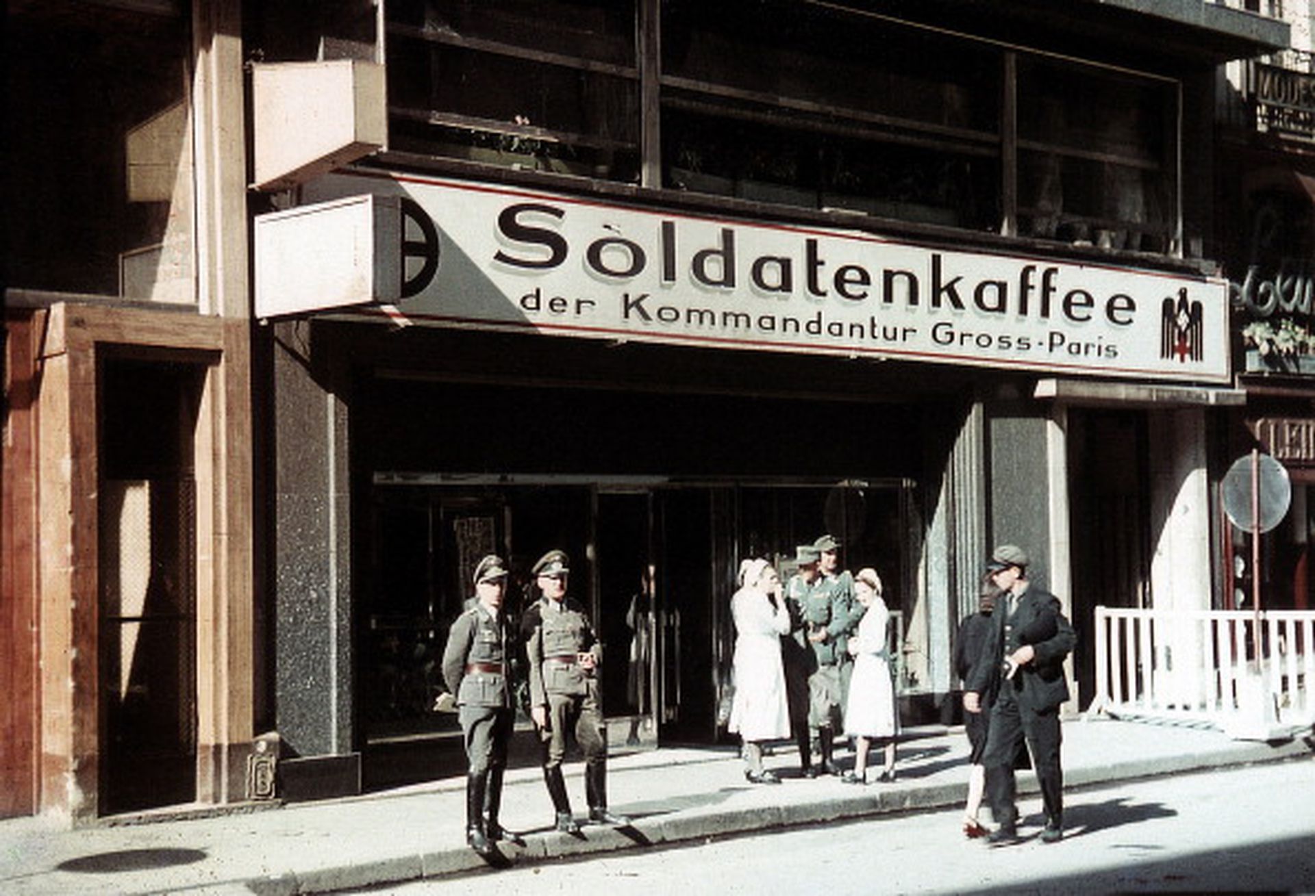 1943年，两名德国国防军军人在巴黎市中心的士兵咖啡屋前休闲放松，在德据时代这一地点成为德国占领军的专属休息地。（Getty Images）